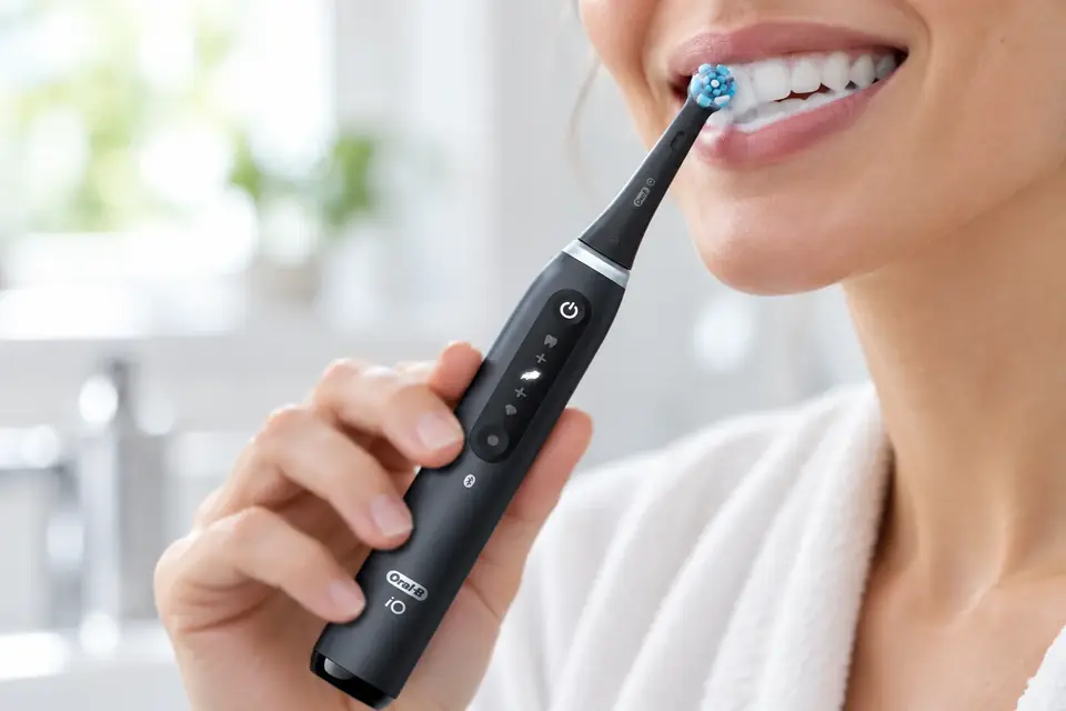 The Oral-B iO Series 5 at work: an electric toothbrush mid-brush beside a clean smile